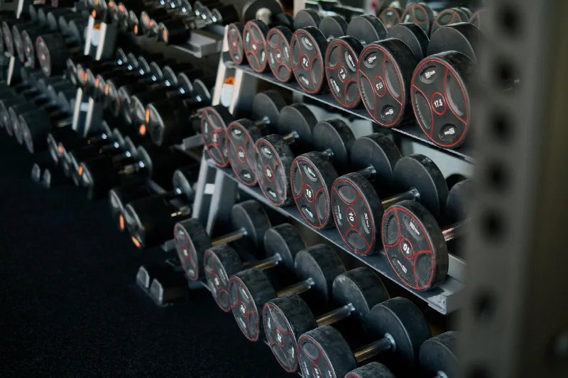Kelderruimte ingericht als fitnessruimte met rubbervloer en spiegelwand